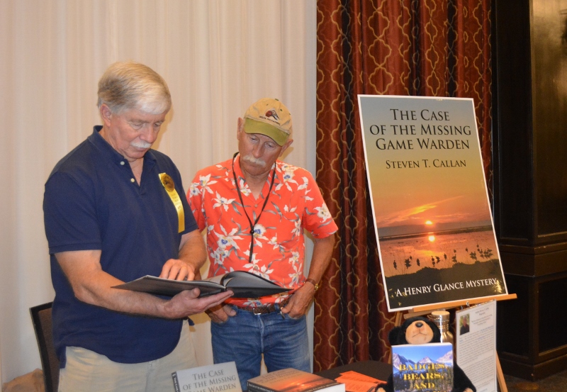 Author Steven T. Callan visits with friend at book signing for his award-winning novel ,The Case of the Missing Game Warden