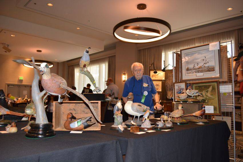 Carver Don Hovie with his artwork at the Pacific Flyway Decoy Association Wildfowl Classic, July 12-13, 2025, at the DoubleTree Hotel, Sacramento, California